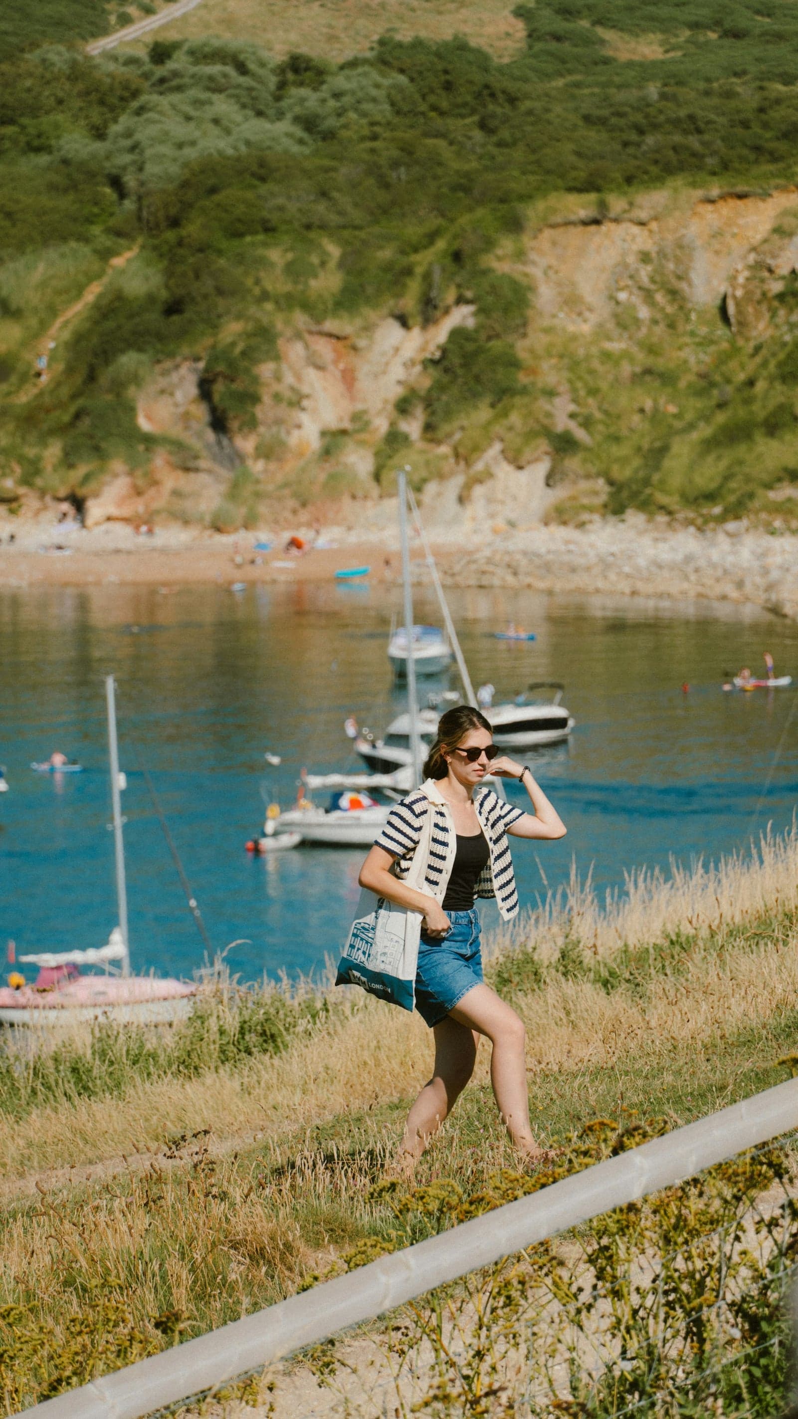 A Westport woman walking a coastal harbor trail — the kind of active life Propper Chiropractic helps patients return to