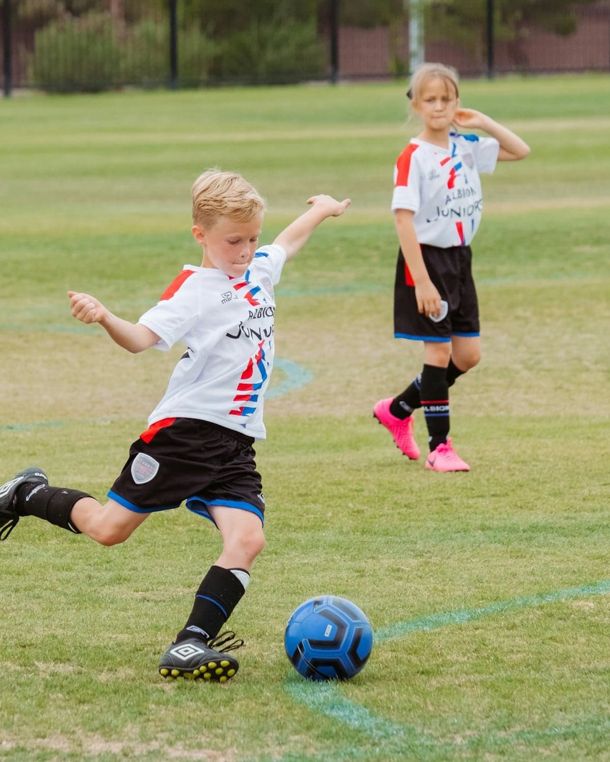 A young soccer player striking the ball during a youth match
